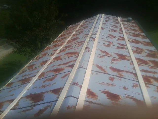 Rusted metal roof panels with new wood purlins before replacement — Storm Damage Roof Repair in Otis Orchards by Roofing Brothers