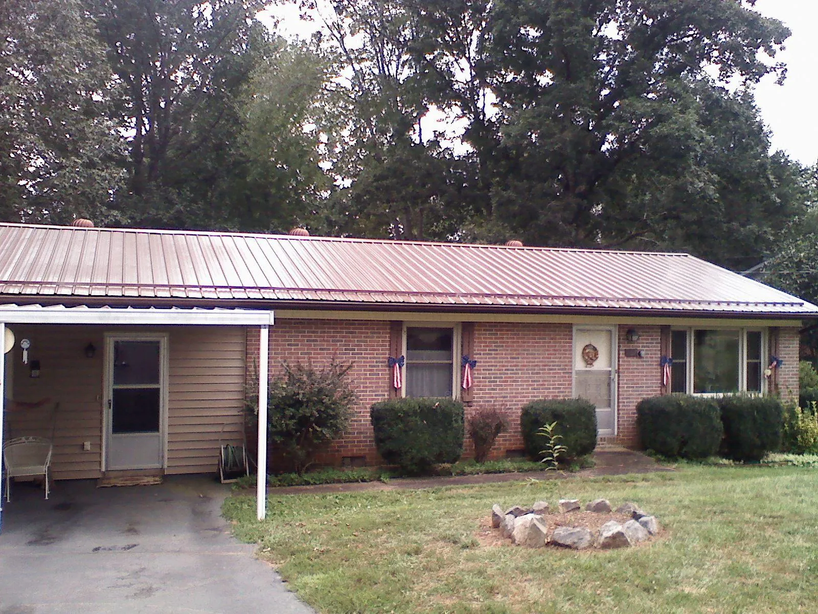 Bronze metal roof and carport on a brick ranch home — Roof Repair work by our crew in Otis Orchards